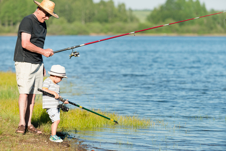 Senior man enjoys in fishing with his grandsonの写真素材