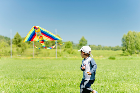 Cute little boy playing with kiteの写真素材