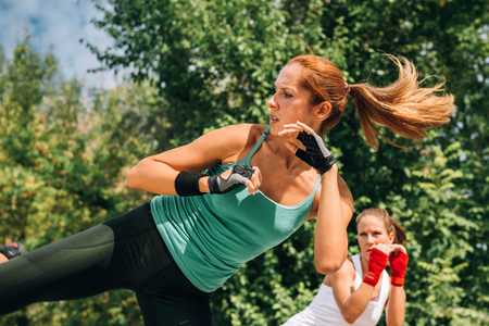 Women doing TaeBo side kicksの写真素材