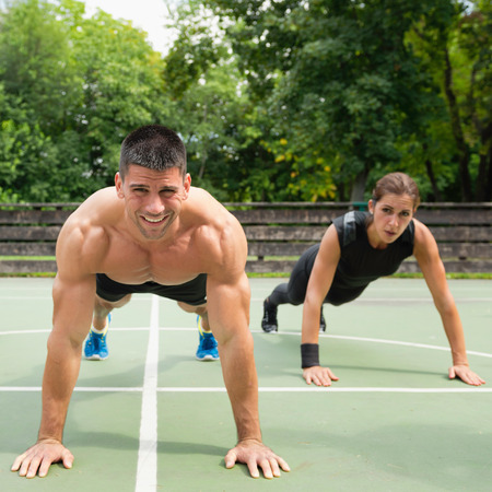 Male and female athletes doing push-upsの写真素材