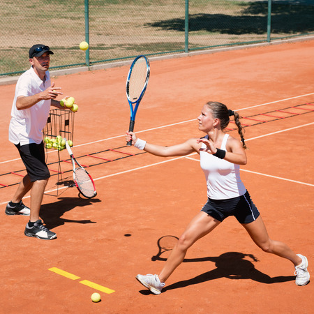 Young woman with instructor on cardio tennis trainingの写真素材