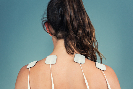 TENS treatment in physical therapy - electrodes placed onto patient's shouldersの写真素材