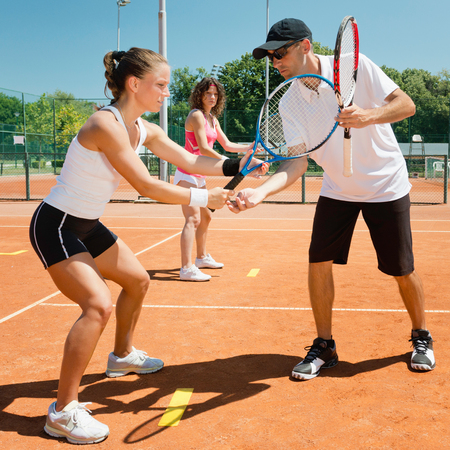 Tennis lessons - instructor working with studentsの写真素材