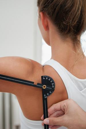 Physiotherapist measure shoulder flexion with goniometer of young femaleの写真素材
