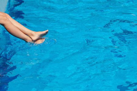 Female legs splashing in the swimming pool, convenient copy spaceの写真素材
