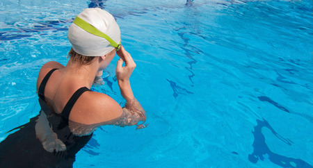 Female swimmer fixing goggles before starting a lap. Convenient copy spaceの写真素材