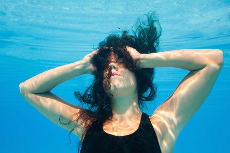 Black hair young female underwaterの写真素材