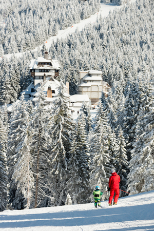 Father and son skiing together, winter landscapeの写真素材