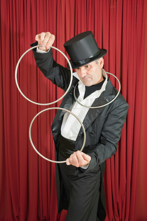 Stage magician doing a classic magic trick with iron ringsの写真素材
