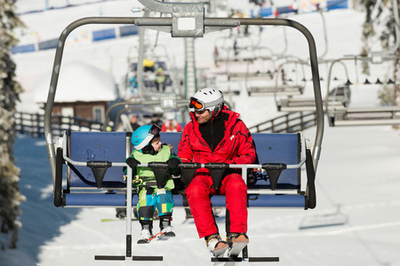 Father and son on ski lift in winter vacation resortの写真素材