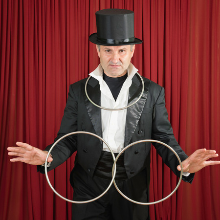 Magician with classic metal ring props, posing on stageの写真素材