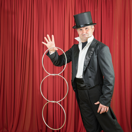 Magician performing trick with rings on stageの写真素材