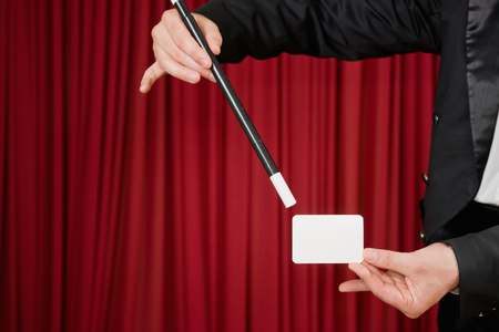 Magician on stage presenting a business card, convenient copy spaceの写真素材