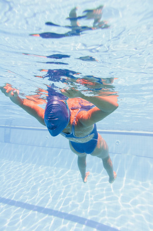 Female relaxing underwater with rised armsの写真素材
