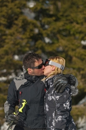 Skiing couple kissing on a mountainの写真素材