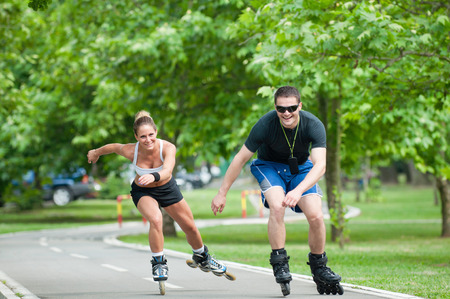 Young couple casually racing on inline skates in a metroparkの写真素材