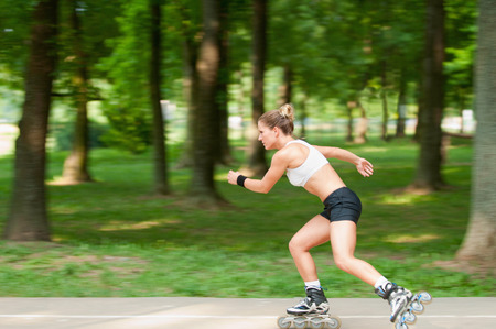 Panning image of fast moving young woman on roller bladesの写真素材