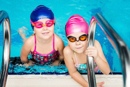 Little girls, indoor swimming pool, looking at camera