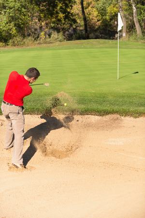 Golfer playing from sand trapの写真素材