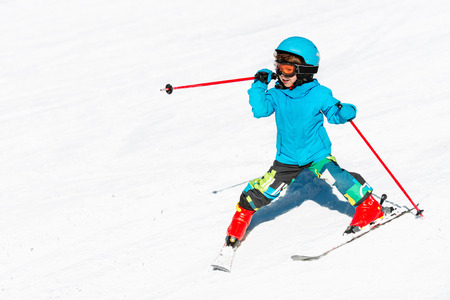 Cute little child skiing down the slopeの写真素材