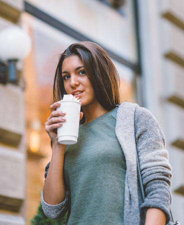 Woman with take-away coffee in the cityの写真素材