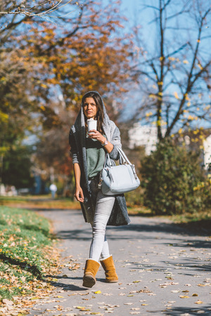 Girl drinking coffee in parkの写真素材