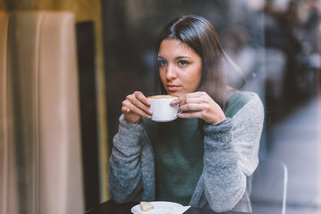 Woman drinking coffee in cafeの写真素材