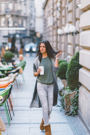 Woman with take-away coffee in the cityの写真素材