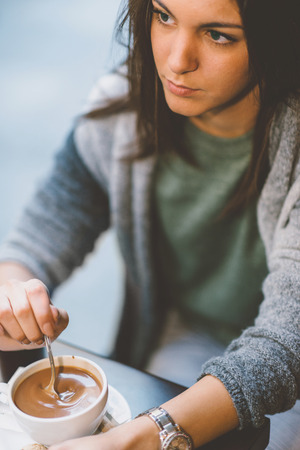 Woman drinking coffee in cafeの写真素材