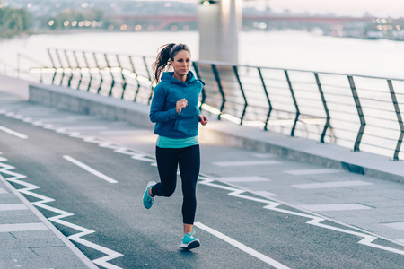 Woman running on riversideの写真素材