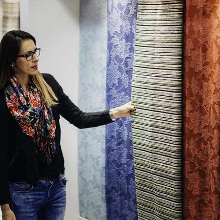 Interior designer looking fabric on fairの写真素材
