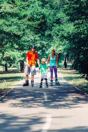 Family with one child roller skating in parkの写真素材