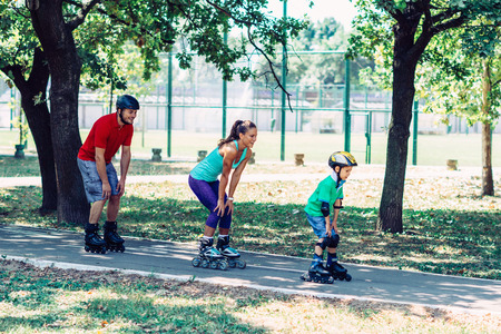 Family with one child roller skating in parkの写真素材