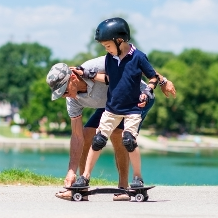 Little boy learning how to ride a snakeboardの写真素材