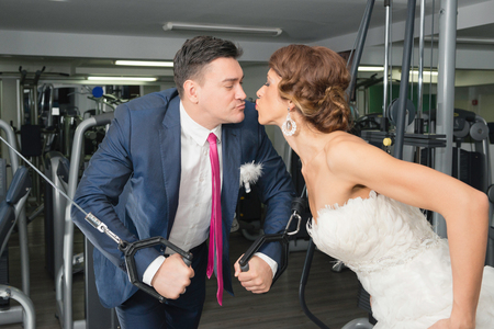 Bride and groom kissing in gymの写真素材