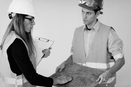 Architects examining tiles on construction siteの写真素材