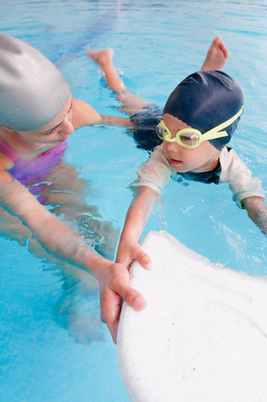 Little boy on swimming class with boardの写真素材