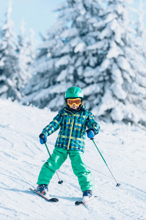 Little boy skiing on mountain on sunny dayの写真素材