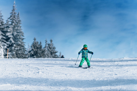 Little boy skiing on mountain on sunny dayの写真素材