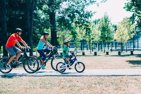 Cheerful family biking in parkの写真素材