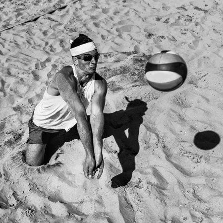Male beach volleyball player about to hit the ballの写真素材