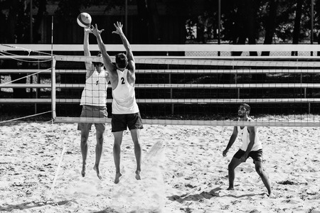 Male team playing beach volleyball