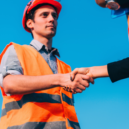 Civil engineers handshaking on construction site after successful meetingの写真素材