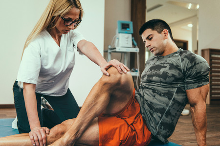 Physical therapist working with male patient