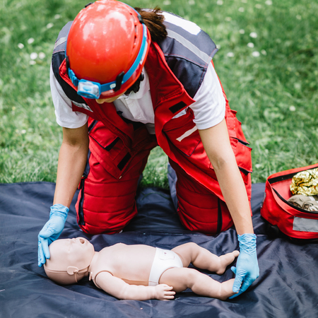 Cpr training on baby dummy outdoors