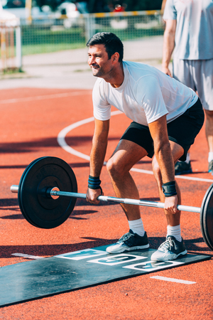 Man with weight lifting bar on crossfit competitionの写真素材