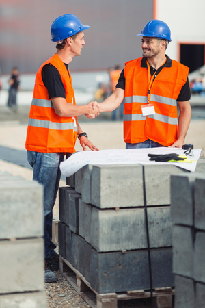 Construction workers handshaking after meeting on construction siteの写真素材