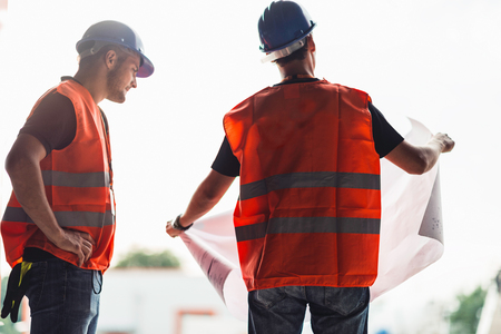 Architects with blueprints on construction siteの写真素材