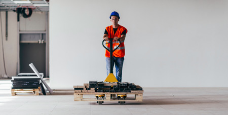 Driving construction material with hand pallet truck