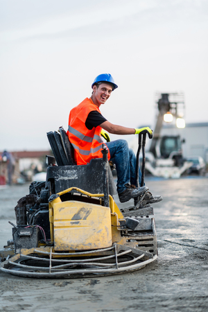 Construction worker levenig concrete on leveling machineの写真素材